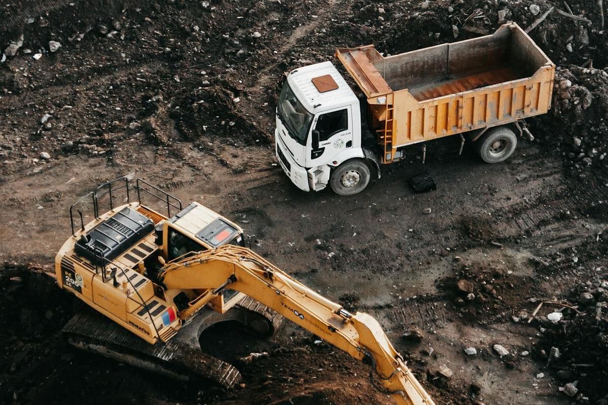 Aerial view of an excavator and tip truck starting earthworks