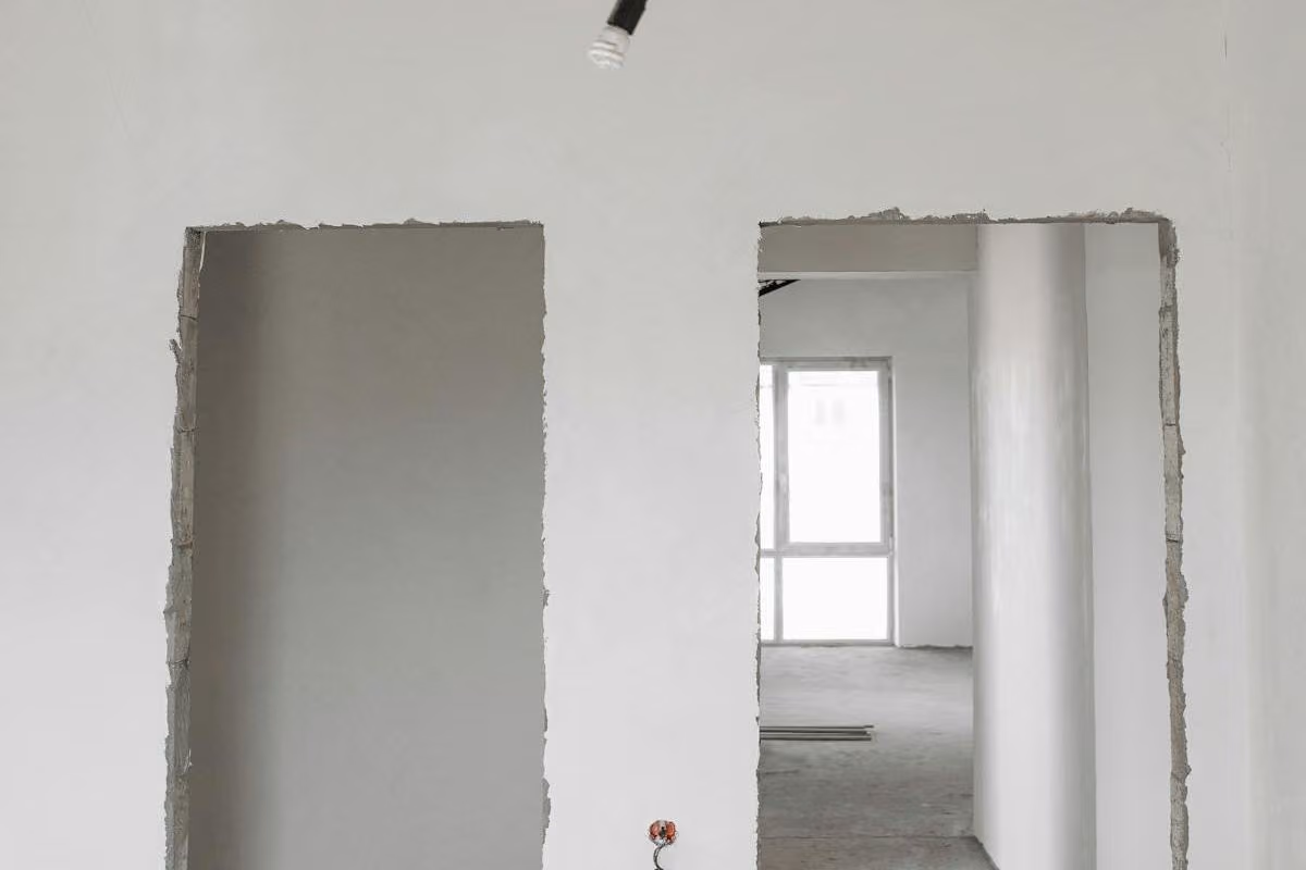Freshly lined empty interior with two open doorways and a bare concrete floor, ready for fit-out