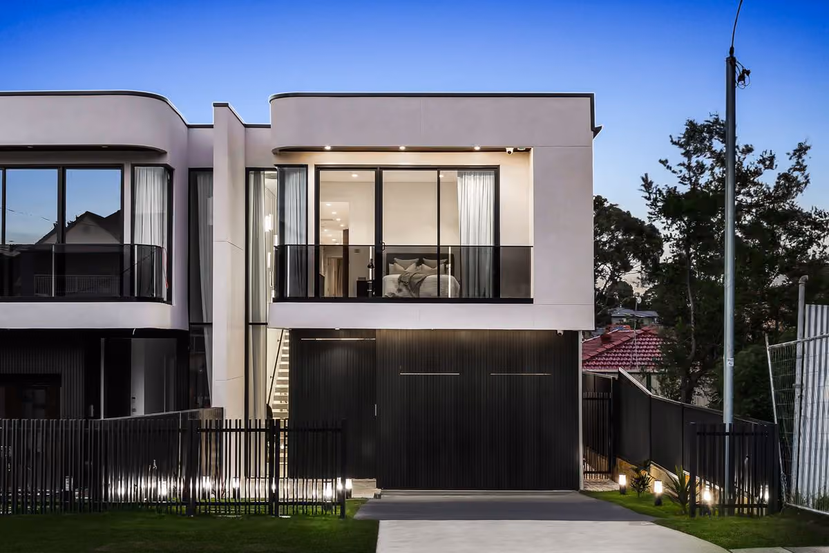 Modern attached duplex with mirrored facade and double garages