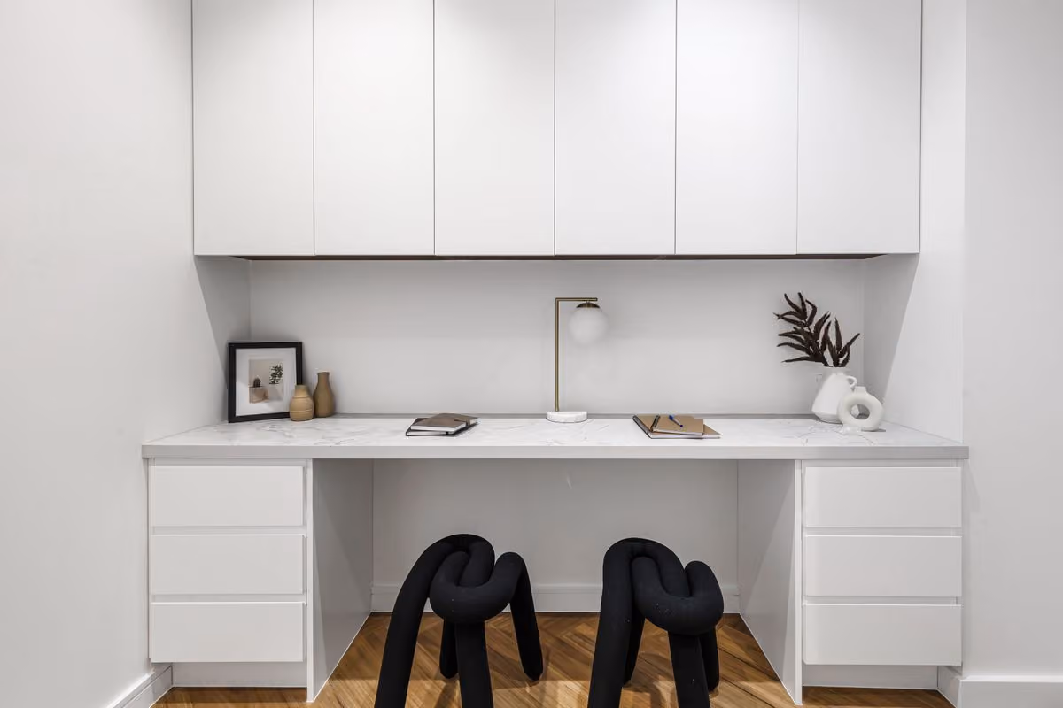 Built-in study desk with white joinery, twin chairs and open shelves