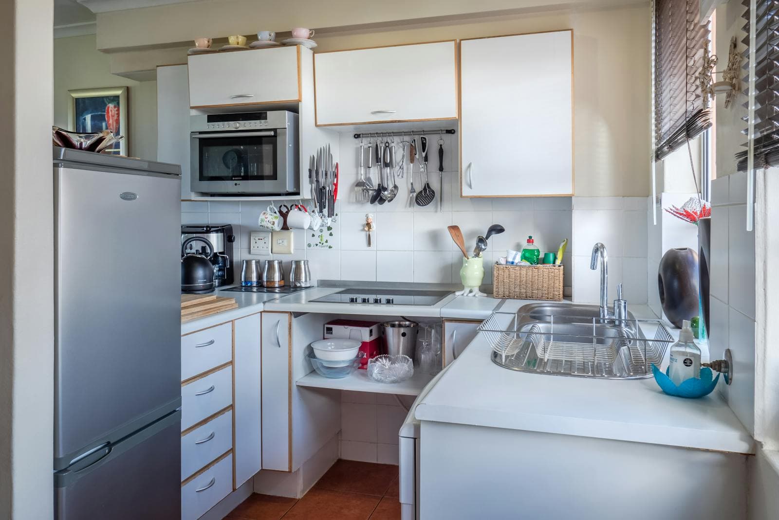 Small older-style kitchen with limited bench space and a single window