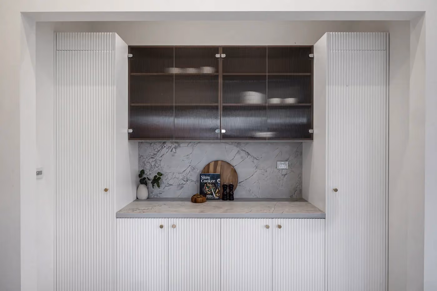 Butler's pantry with timber-look upper cabinets, white lower drawers and a stone benchtop