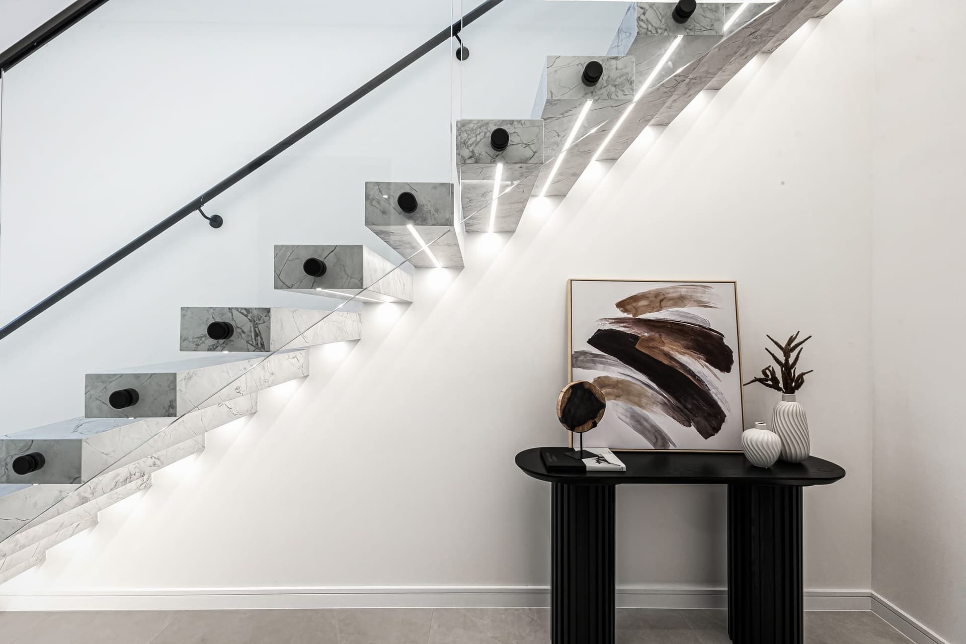 Timber staircase rising through a double-height void with a tall window