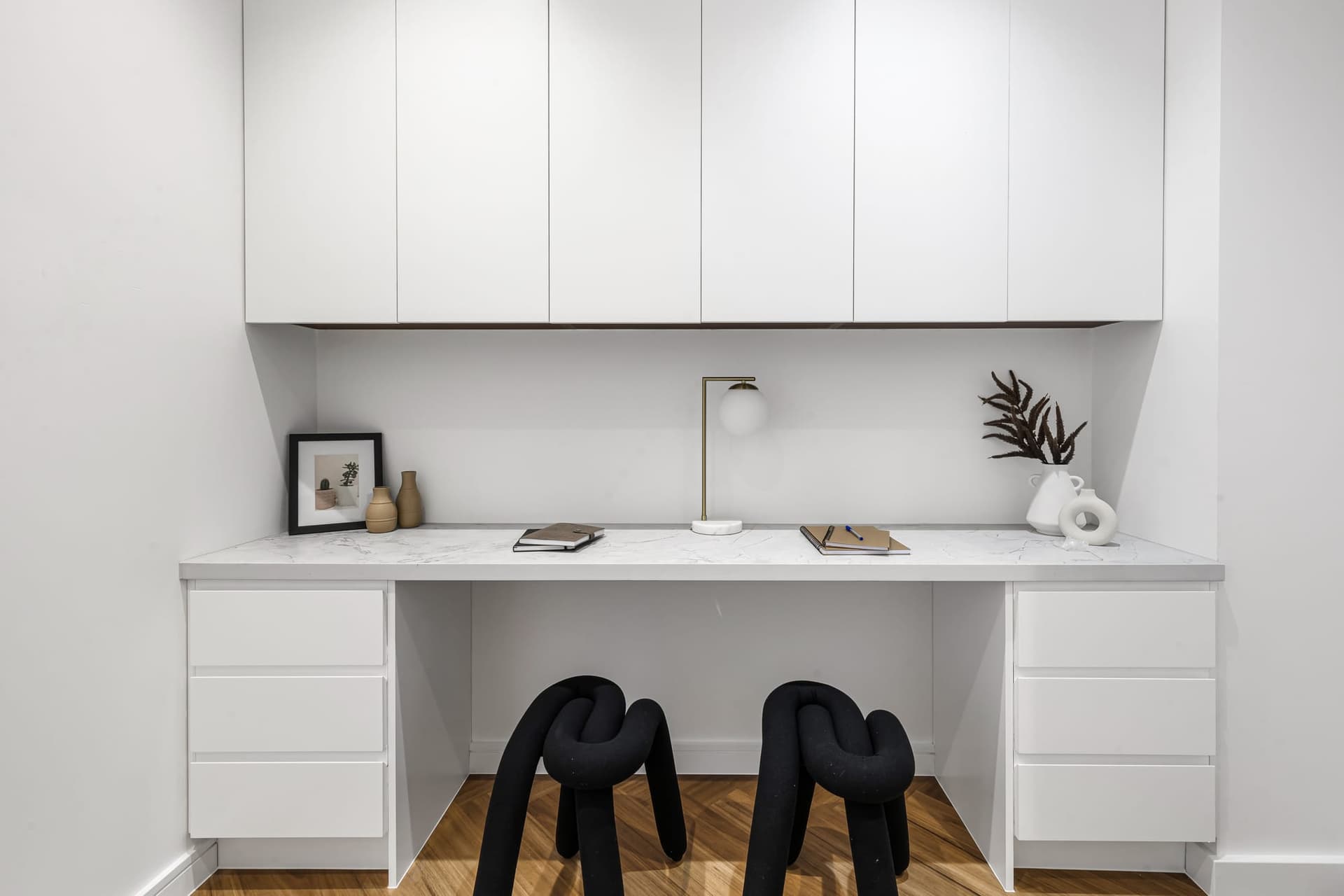 Built-in study nook with white joinery, two desk spaces and floating shelves